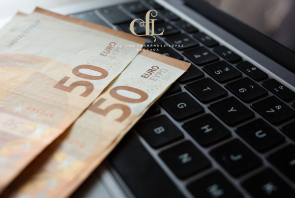 50-euro banknotes draped over a laptop keyboard, with a decorative logo above them.